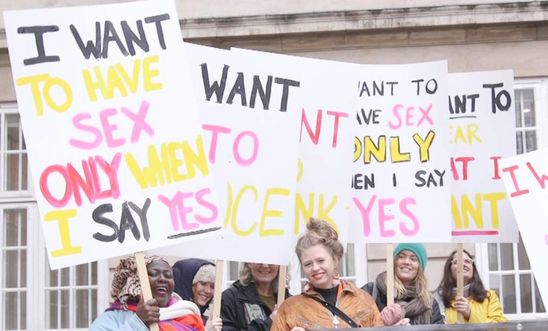 Women stand together hold placards that read "I want to have sex only when I say yes"