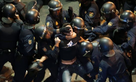 A demonstrator struggles with riot police in Madrid, 2012
