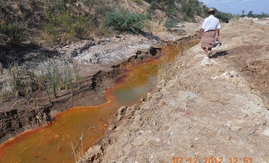 reddish-orange water in drainage channel near mines 