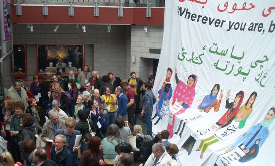 Large banner of women's rights in Afghanistan with conference delegates Large banner of women's rights in Afghanistan with conference delegates