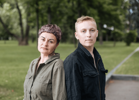 Sphere NGO founders Anna and Vira stand back to back outside looking at camera