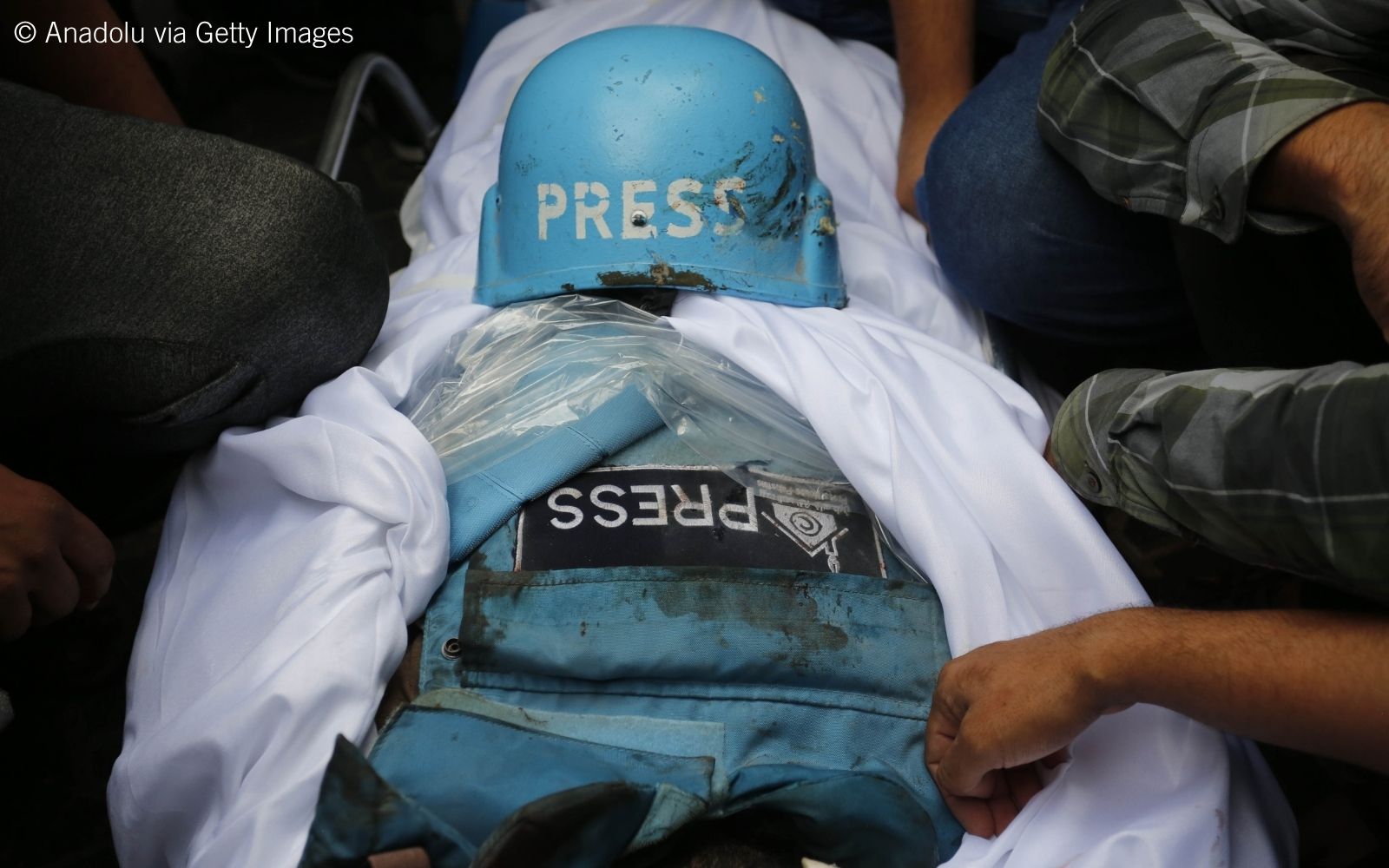 press vest and shroud covering the body under a press helmet during the funeral ceremony of Palestinian journalists press vest and shroud covering the body under a press helmet during the funeral ceremony of Palestinian journalists