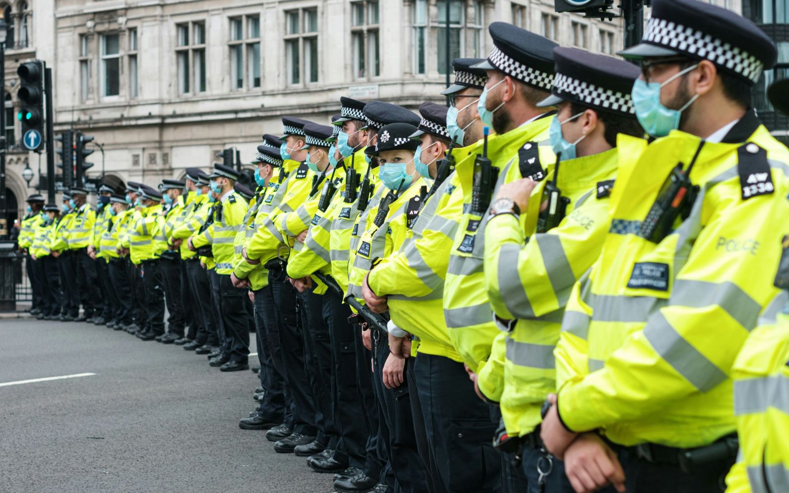 Row of British police officers lined up on a main street Row of British police officers lined up on a main street