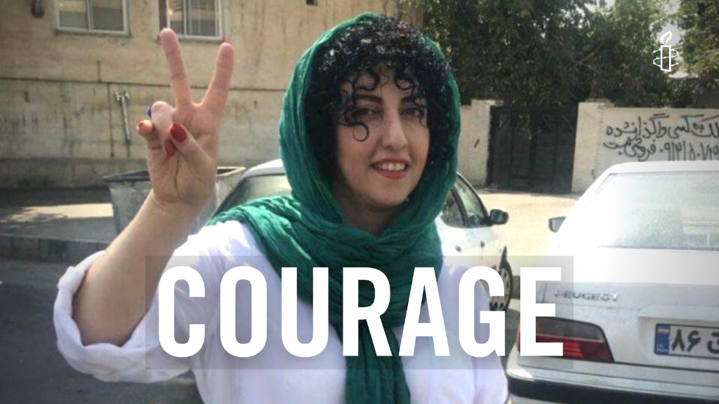 "Narges smiles as she walks along holding her fingers up in a peace symbol. Text overlay reads: Courage""