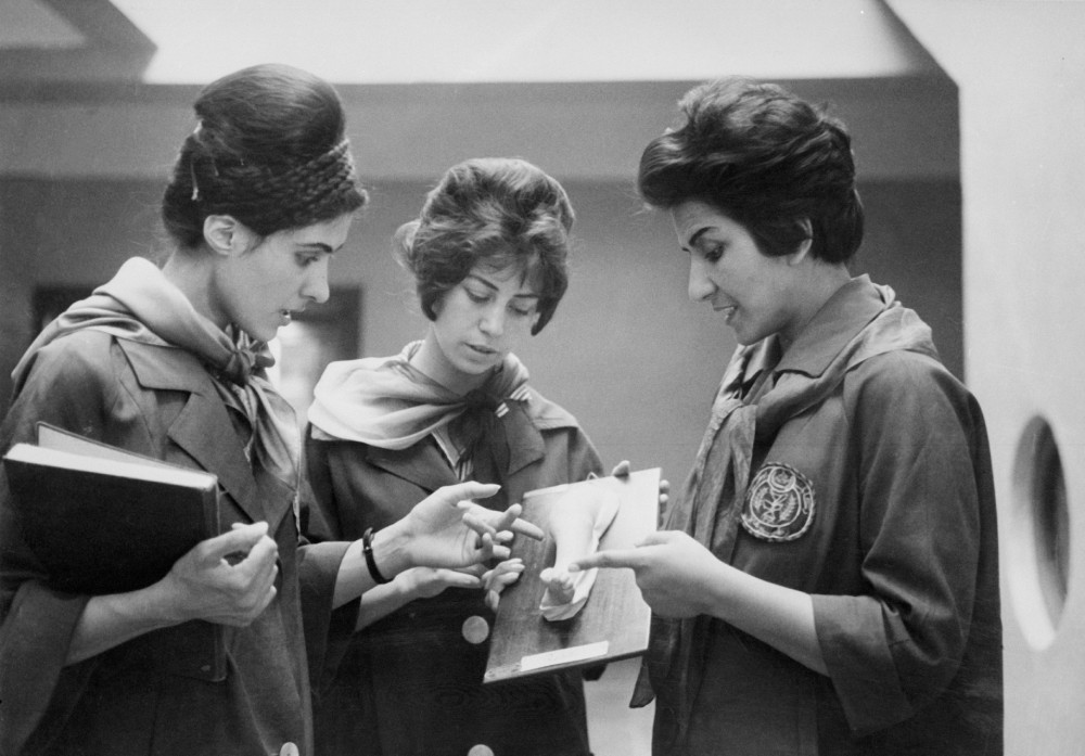 KABUL, AFGHANISTAN - JANUARY 1: Picture taken in 1962 at the Faculty of Medecine in Kabul of two Afghan medicine students (Left and Center) listening to their Professor as they examine a plaster showing a part of a human body. (STAFF/AFP via Getty Images)