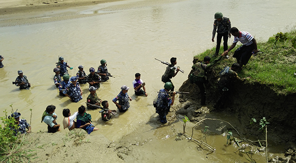 Myanmar security forces accompany Hindu villagers to the site of mass graves where their relatives were buried.