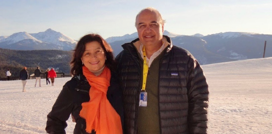 Morad Tahbaz with his wife pose and smile at camera, against a snowy landscape
