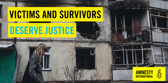 A person walks by a building with evidence of shelling. a banner reads "victims and survivors deserve justice".
