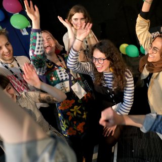 Group of people raising their hands in the air at the Amnesty International UK office.