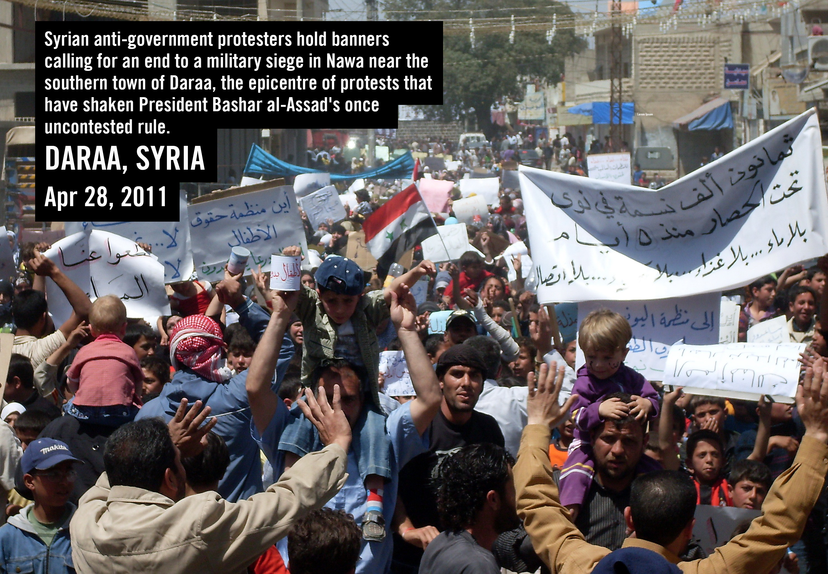 Syrian anti-government protesters hold banners calling for an end to a military siege in Nawa