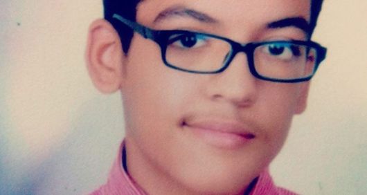 14-year-old Aser poses for school photo. 