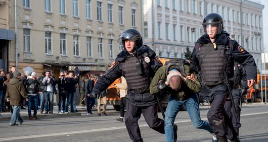 Riot police officers detain a protester during an unauthorised anti-corruption rally in central Moscow.