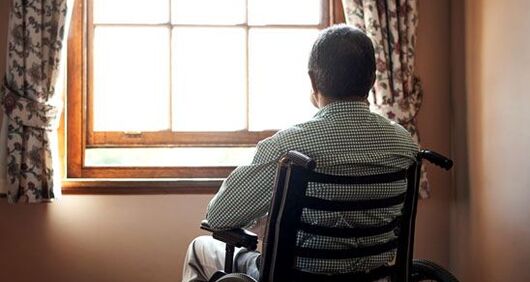 Elderly man looking out window