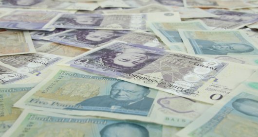 A pile of scattered UK notes A pile of scattered UK notes
