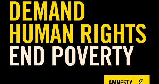 A black placard that reads Demand Human Rights, End Poverty with an Amnesty logo in the bottom-right corner