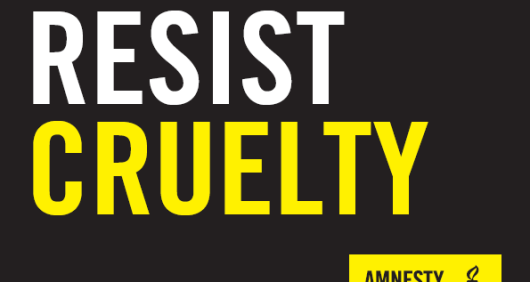 A black placard that reads 'Resist Cruelty' with an Amnesty logo in the bottom-right corner