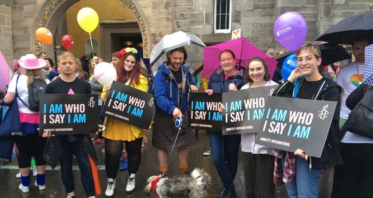 Amnesty Volunteers marching at Edinburgh Pride with trans rights placards saying 'I Am Who I Say I Am' Amnesty Volunteers marching at Edinburgh Pride with trans rights placards saying 'I Am Who I Say I Am'