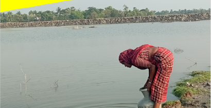A woman drawing water from a river using a clay pot