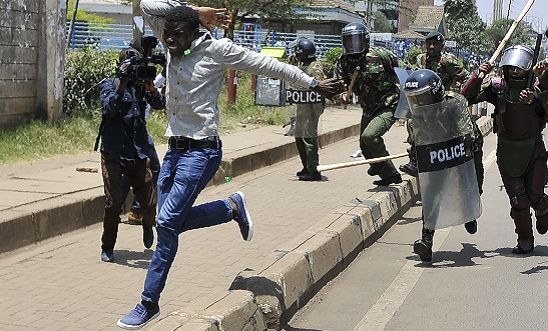 A protestor runs from anti-riot police on 26 September 2017 in Nairobi, during a demonstration to demand the removal of officials from national election oversight body