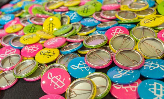 colourful badges with amnesty candle logo 