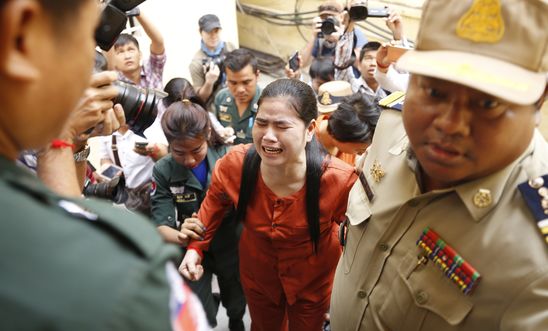 Image shows Tep Vanny approaching the court, accompanied by a uniformed guard