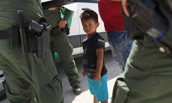 US Border Patrol agents take into custody a father and son from Honduras near the US-Mexico border, 12 June 2018