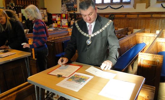 Mayor signing cards