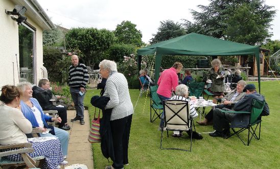 People drinking tea in a garden