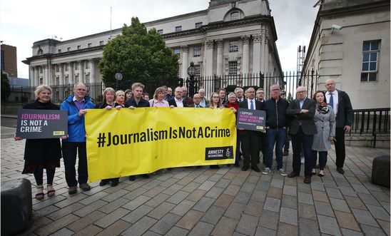 Image shows a group of people with a banner that says 'journalism is not a crime' Image shows a group of people with a banner that says 'journalism is not a crime'