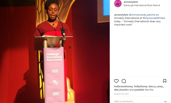 Image shows a woman reading at a lectern Image shows a woman reading at a lectern