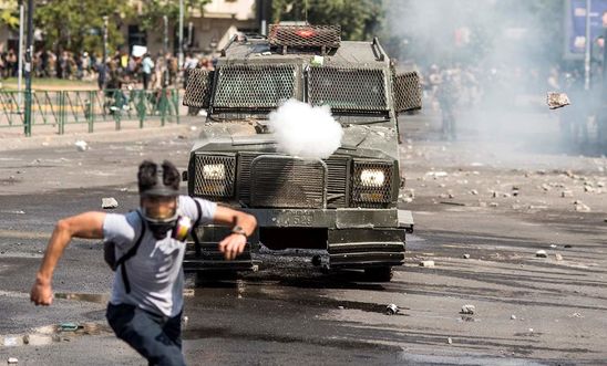 A protester runs away from security forces