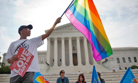 Activist Carlos McKnight waves a flag in support of same-sex marriage outside the Supreme Court.