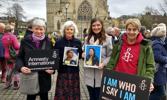 Four people holding banners