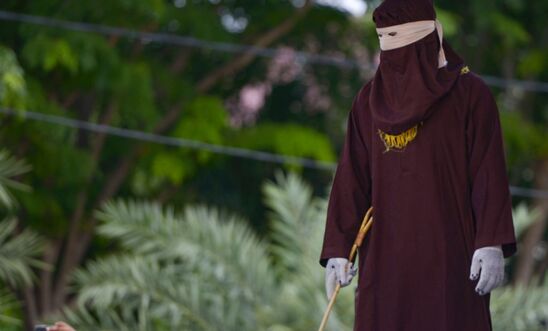 A member of the Sharia police waits before a public caning in Banda Aceh on October 21, 2019