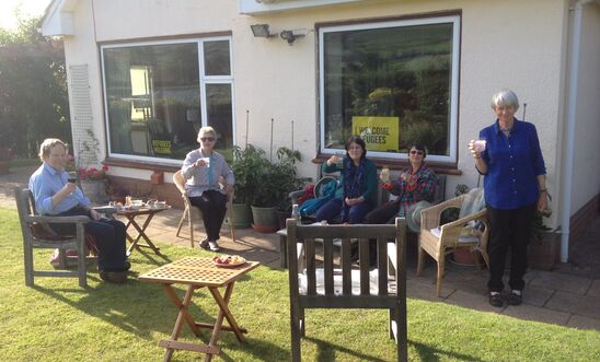 People in a garden drinking tea