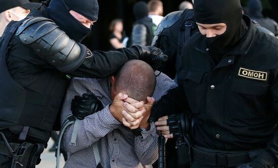 Police officers detaining a protester in Minsk on 10 August