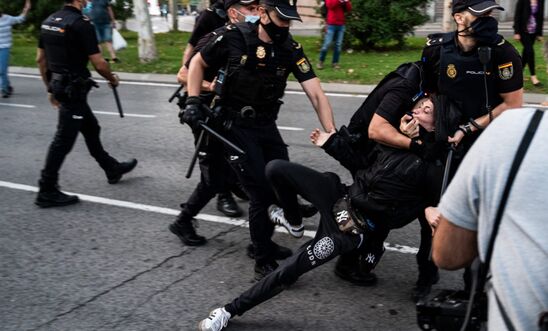 Police arresting a protester in Madrid, Spain, after violent clashes during a protest against the new measures to stop the spread of coronavirus.