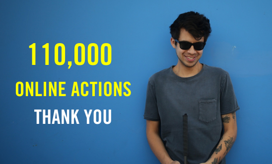 Image of Gustavo Gatica standing in front of a blue wall with '110,000 online actions thank you' text Image of Gustavo Gatica standing in front of a blue wall with '110,000 online actions thank you' text