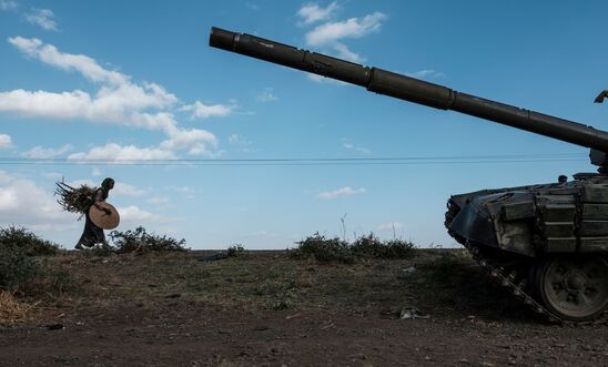 A woman carrying crops walks next to an abandoned tank belonging to Tigrayan forces south of the town of Mehoni, Ethiopia, on December 11, 2020. The town of Mehoni, located in Southern Tigray, experienced shelling resulting in civilian deaths and injured people. (Photo by EDUARDO SOTERAS / AFP) (Photo by EDUARDO SOTERAS/AFP via Getty Images)