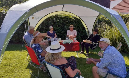 People in a tent drinking tea