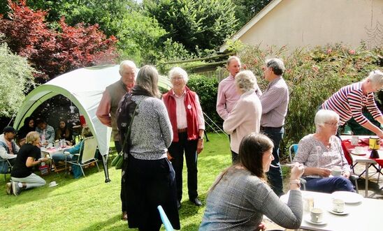 People in a garden drinking tea