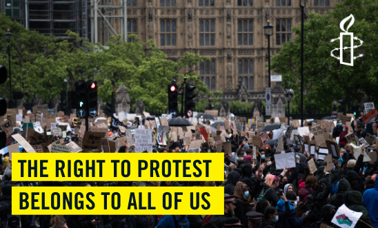 Protest march with text reading: The right to protest belongs to all of us Protest march with text reading: The right to protest belongs to all of us