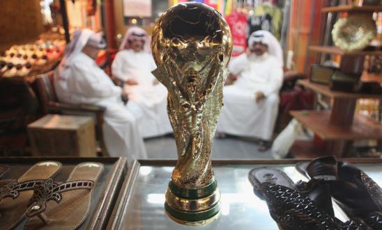 Arab men sit at a shoemaker's stall with a replica of the FIFA World Cup trophy in the Souq Waqif traditional market Arab men sit at a shoemaker's stall with a replica of the FIFA World Cup trophy in the Souq Waqif traditional market