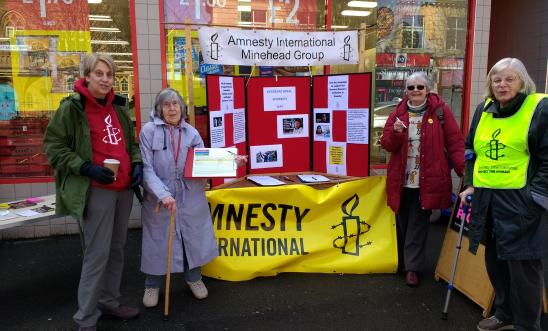 four Amnesty members with street stall