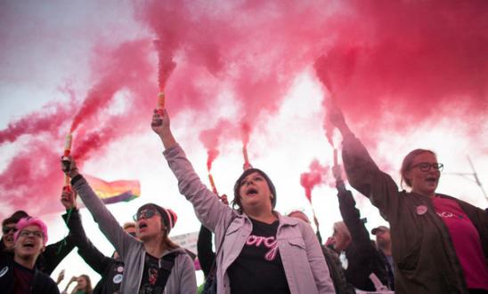 Protesters hold flares during Pro Choice March in Warsaw in 2018