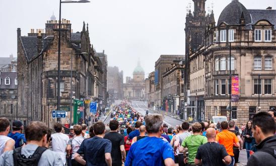 Hundreds of people run alongside a beautiful Edinburgh street