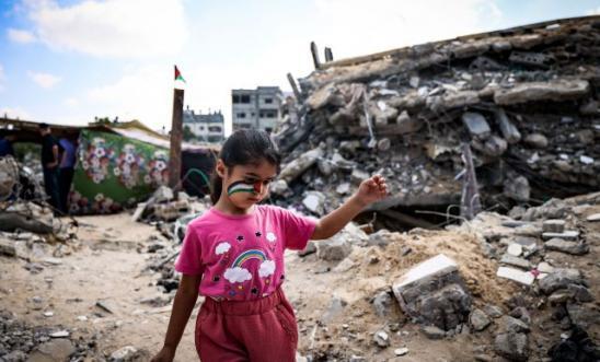 A Palestinian girl in the rubble of buildings destroyed by Israel's bombardment in Beit Lahia in the Gaza Strip last year