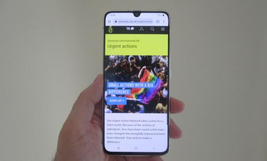 Image shows a hand holding a phone with the Pocket Protest website