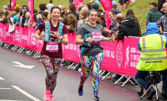 Image shows 2 people running in the Yorkshire Marathon.