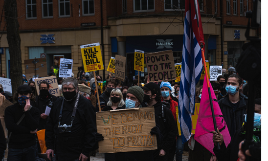 People protesting standing up for their right to do so. They hold placards and banners. 